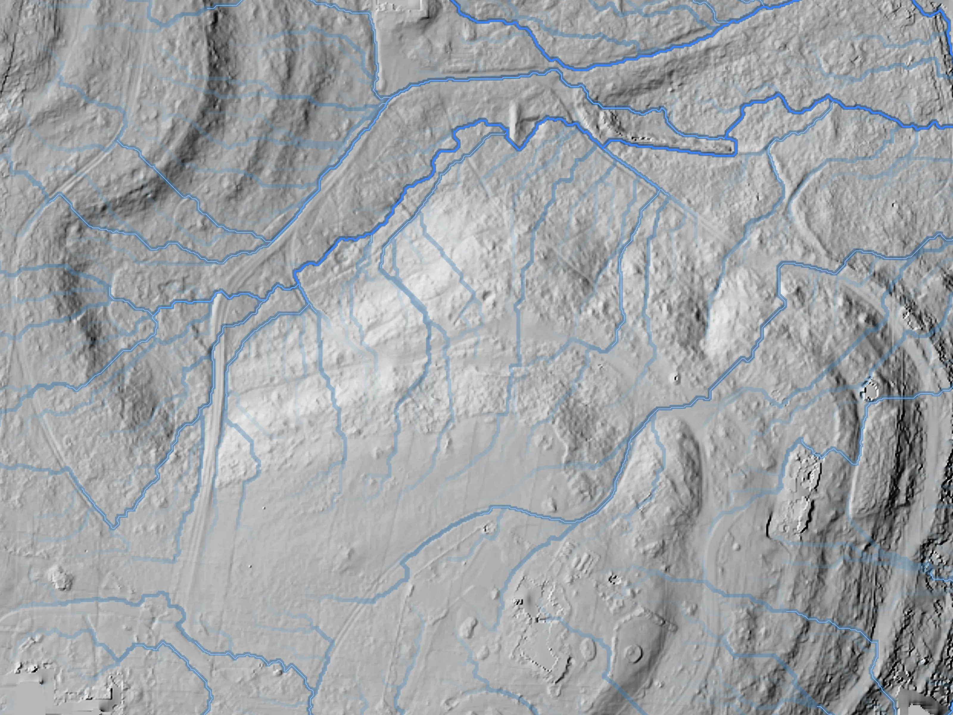 Modeled drainage network over the flow and bare-earth relief of our showcase ranch, from July 2026 LiDAR.